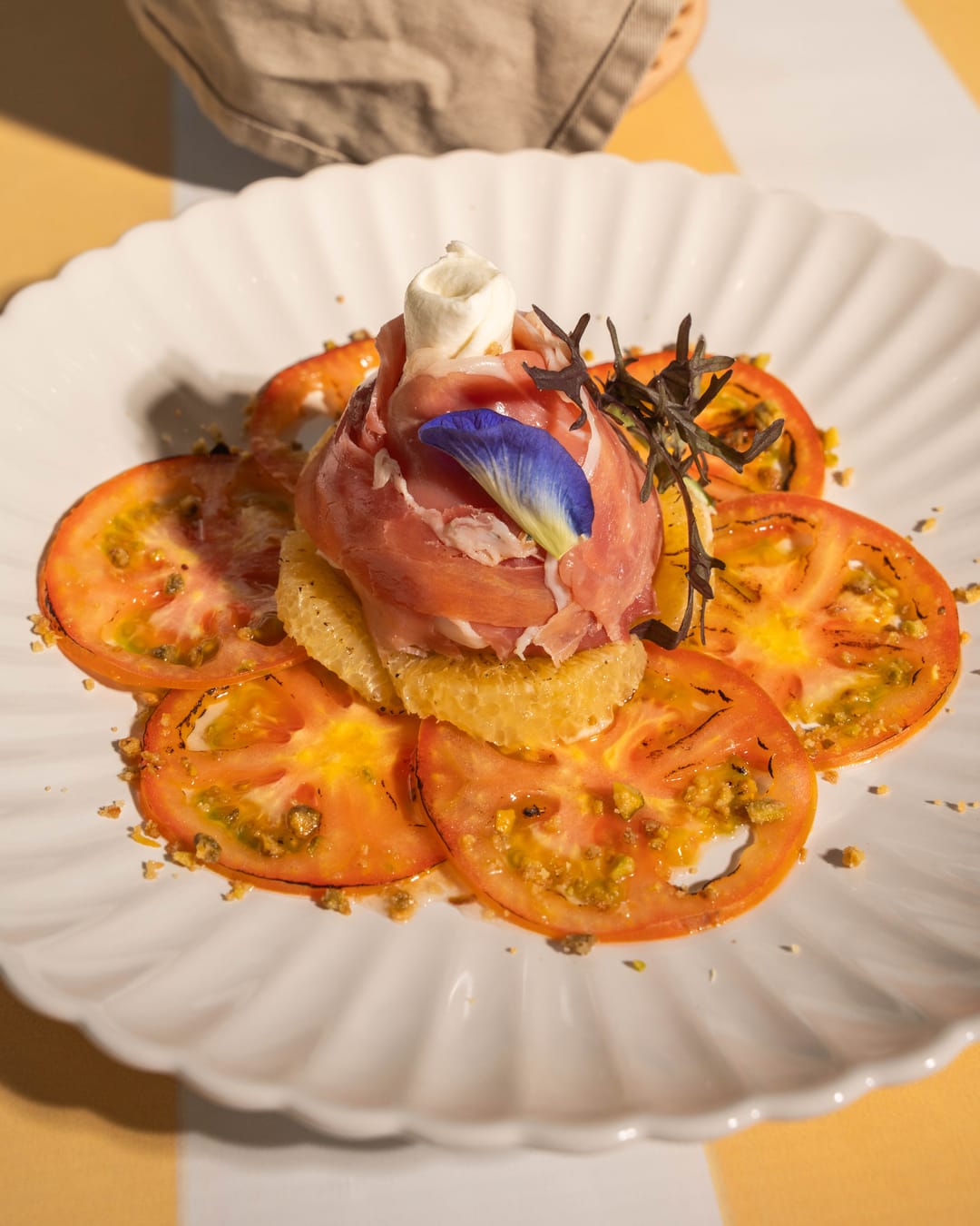 Burrata Pradera: tomate, toronja caramelizada y prosciutto