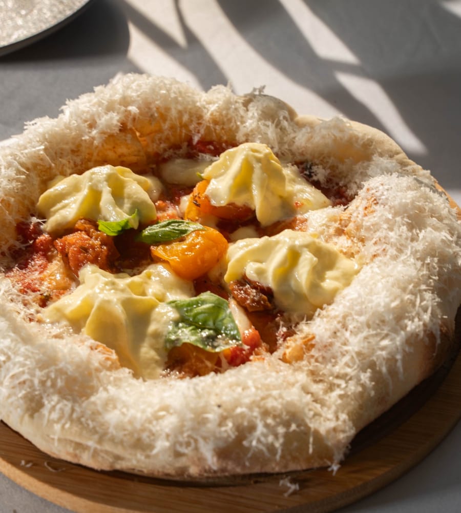 Pizza con burrata, tomate amarillo y albahaca